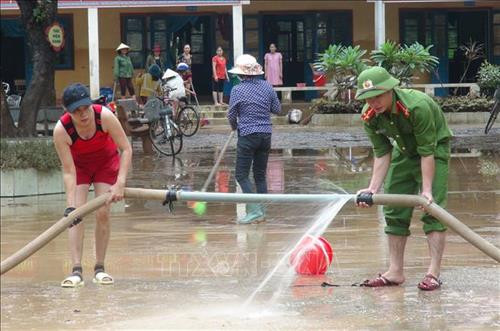 Dọn dẹp khắc phục hậu quả lũ lụt. Ảnh: Đức Thọ - TTXVN