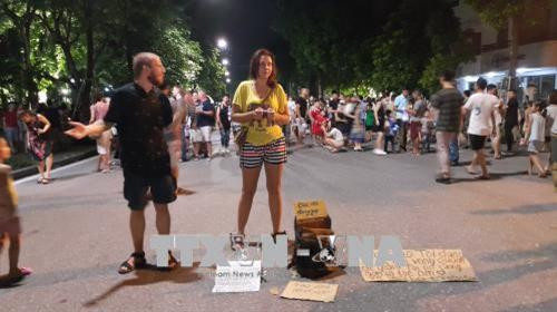 Nhóm người nước ngoài mời ôm để khách ủng hộ tiền đi du lịch vòng quanh thế giới. Ảnh: Nguyễn Cúc - TTXVN Nhóm người nước ngoài mời ôm để khách ủng hộ tiền đi du lịch vòng quanh thế giới. Ảnh: Nguyễn Cúc - TTXVN