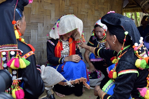 Trước khi về nhà chồng, cô dâu được mẹ chú rể mặc cho bộ quần áo mới, đeo đồ trang sức vòng tay, vòng cổ.