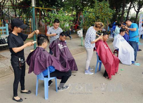 Cắt tóc miễn phí cho các thiếu nhi tại công viên Khánh Hội, quận 4. Ảnh: An Hiếu - TTXVN