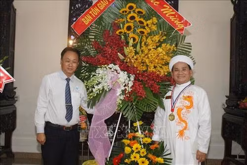 Đại diện Ban Tôn giáo Chính phủ tặng hoa chúc mừng Ngày khai sinh đạo Cao Đài. Ảnh: Tiến Lực - TTXVN