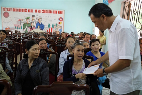 Đại diện Quỹ Vì nỗi đau da cam TTXVN trao quà cho các nạn nhân nhiễm chất độc da cam tại xã Triệu Trung, huyện Triệu Phong. Ảnh: Trần Tĩnh – TTXVN