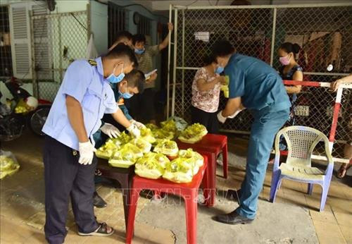 Các cơ quan chức năng cung cấp suất ăn cho người dân Chung cư 1A - 1B Nguyễn Đình Chiểu sau khi chung cư bị phong tỏa. Ảnh: TTXVN phát