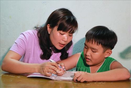 Cô giáo Triệu Thị Nhập dạy học cho con tại nhà. Ảnh: K GỬIH -TTXVN Cô giáo Triệu Thị Nhập dạy học cho con tại nhà. Ảnh: K GỬIH -TTXVN