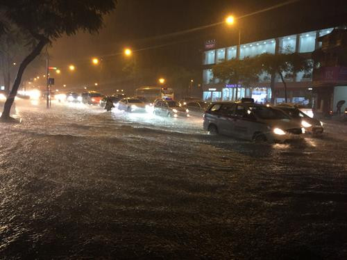 Mưa lớn gây ngập nặng tại phố Nguyễn Văn Cừ. Ảnh: An Văn Đăng - TTXVN