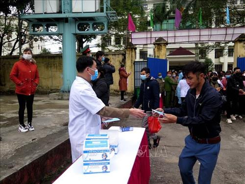 Lực lượng y tế phát khẩu trang miễn phí cho người dân Thái Nguyên đến dự Lễ giao nhận quân tại thành phố Thái Nguyên. Ảnh: Thu Hằng-TTXVN