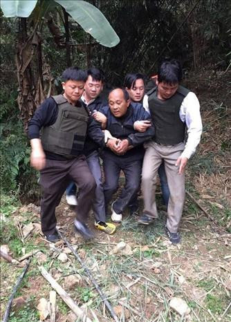 Công an huyện Tân Uyên bắt giải đối tượng Hạng A Lau vận chuyển 39 bánh heroin có súng trốn chạy vào rừng. Ảnh: TTXVN phát Công an huyện Tân Uyên bắt giải đối tượng Hạng A Lau vận chuyển 39 bánh heroin có súng trốn chạy vào rừng. Ảnh: TTXVN phát