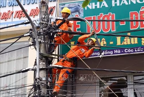 Cán bộ điện lực thành phố Lào Cai sửa chữa đường điện trong địa bàn. Ảnh: Quốc Khánh - TTXVN