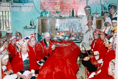 Các nàng dâu mặc trang phục đỏ quạt ma trong một đám tang.