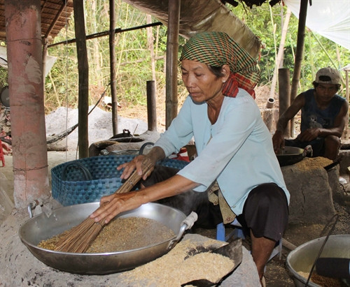 Cốm được rang chin trước khi đâm dẹp để sàng sảy.