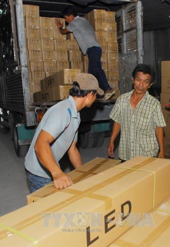 Vận chuyển hàng thu giữ để tiếp tục điều tra, xử lý theo qui định của pháp luật. Ảnh: Mạnh Linh - TTXVN