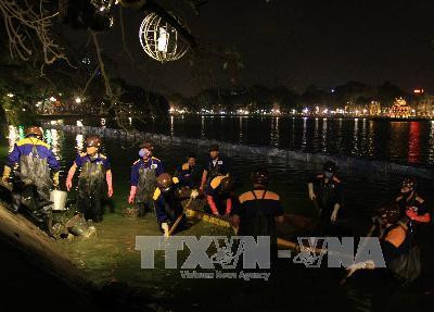Công nhân Công ty TNHH Nhà nước một thành viên Thoát nước Hà Nội nạo vét khu vực mặt nước gần bờ xung quanh Hồ Gươm hồi tháng 2/2011. Ảnh: Nhật Anh - TTXVN