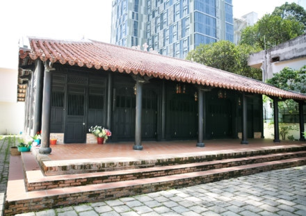 Ngôi nhà cổ được xây từ năm 1799 - Ảnh : Ngọc Tiến. Ngôi nhà được chúa Nguyễn Ánh cho xây dựng vào năm 1799 theo lối kiến trúc truyền thống của Việt Nam với ba gian, hai chái làm nơi trú ngụ cho Giám mục Bá Đa Lộc (quốc tịch Pháp, sinh năm 1741), người dạy học cho hoàng tử Nguyễn Cảnh lúc đó. Ban đầu ngôi nhà được xây dựng bên phần đất của Thảo Cầm Viên bây giờ. Năm 1911, khi Tòa Tổng Giám mục hiện nay được xây dựng hoàn thành, ngôi nhà dời về đây và được giữ gìn, bảo quản đến ngày hôm nay - Ảnh : Ngọc Tiến. Qua những lần di dời trước đó, phần nền đất làm cho cột trụ ngôi nhà bị hư hỏng. Sau đợt trùng tu nền nhà được nâng cao hơn, cột trụ ngôi nhà được đặt trên những tảng đá để đỡ một phần tải trọng và chắc chắn hơn như nguyên bản ngôi nhà ban đầu - Ảnh : Ngọc Tiến. Dàn rui lách, kèo và hệ thống vách được xếp đặt một cách tinh xảo - đó là nét độc đáo và giá trị to lớn về lịch sử và văn hóa ngôi nhà - Ảnh : Ngọc Tiến. Mái nhà được lợp ngói âm dương với những họa tiết hoa văn viền tinh xảo. Hiện nay, lớp ngói đỏ đã được làm mới thay cho lớp ngói cũ rêu phong - Ảnh : Ngọc Tiến. Các cánh cửa làm bằng gỗ quý, hoa văn được điêu khắc tinh xảo tạo thêm nét cổ kính cho mặt tiền của căn nhà - Ảnh : Ngọc Tiến. Ngôi nhà được làm hoàn toàn bằng gỗ quý, khung nhà được liên kết chặt chẽ với nhau hoàn toàn bằng kỹ thuật ghép mộng của những nghệ nhân thời xưa. Hoàn toàn không dùng bất cứ cây đinh nào nhưng ngôi nhà vẫn đứng vững qua hàng trăm năm - Ảnh : Ngọc Tiến. Các nét chạm khắc trên những bộ cửa, vách nhà chưa bị bào mòn và còn nguyên vẹn - Ảnh : Ngọc Tiến. Họa tiết trang trí được khắc họa tỉ mỉ, công phu đặt ngay cửa chính diện tạo sự cân đối và cổ kính, thể hiện nét sáng tạo độc đáo - Ảnh : Ngọc Tiến. Nhiều vật dụng trong nhà như bàn, ghế, tủ, bình phong... vẫn được giữ nguyên vẹn và còn khá tốt. Những chùm đèn được thay mới vì đèn cũ đã hư hỏng, không thể sử dụng được nữa - Ảnh : Ngọc Tiến.