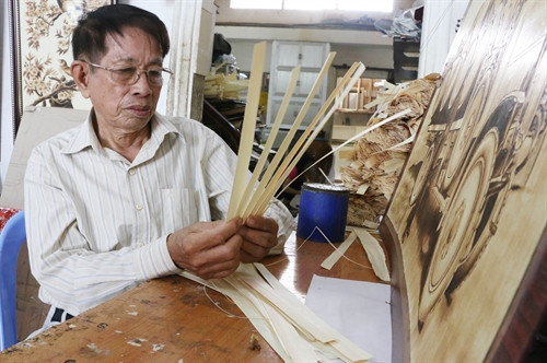 Ông Võ Văn Tạng kiểm tra chất lượng lá thốt nốt trước khi vẽ. Ông Võ Văn Tạng kiểm tra chất lượng lá thốt nốt trước khi vẽ.