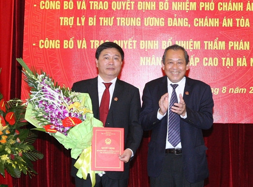 Đồng chí Trương Hòa Bình, Bí thư Trung ương Đảng, Chánh án Tòa án Nhân dân Tối cao trao Quyết định của Ban Tổ chức Trung ương cho đồng chí Nguyễn Đức Bình, nguyên Chánh án Tòa án Nhân dân thành phố Hà Nội làm Trợ lý Bí thư Trung ương Đảng, Chánh án Tòa án Nhân dân Tối cao Ảnh: Thống Nhất-TTXVN