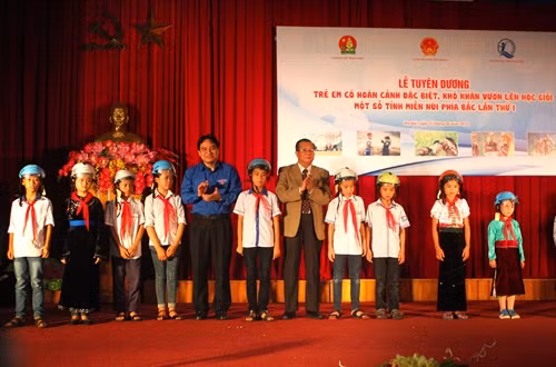 Các đơn vị, tổ chức biểu dương và trao quà tặng cho các em có hoàn cảnh khó khăn. Ảnh: Trung Kiên- TTXVN