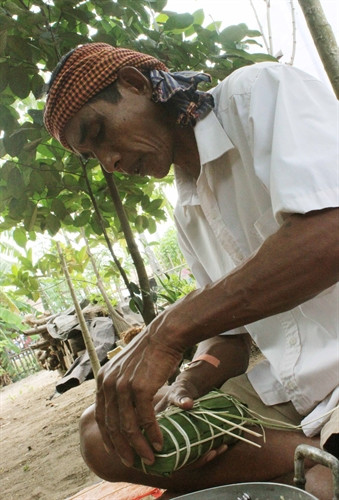 Để bánh tét có hình thức đẹp, độ chín dền đều đòi hỏi người gói bánh phải khéo tay, gói có kỹ thuật. Ảnh: Chanh Đa- TTXVN