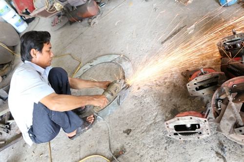 Nông dân Phạm Thanh Liêm đang gia công các chi tiết máy nông nghiệp tại xưởng sản xuất