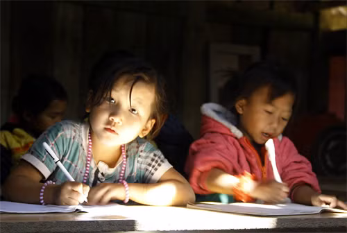 Trẻ em ở bản người Mông Lũng Luông đã được học bài dưới ánh đèn điện. Ảnh: Thu Hằng