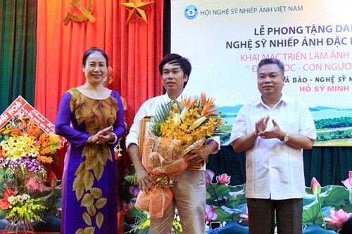 Đại diện lãnh đạo tỉnh Nghệ An tặng Bằng khen cho nhà báo, nghệ sỹ nhiếp ảnh Hồ Sỹ Minh. Ảnh: Tá Chuyên – TTXVN