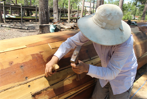 Người thợ làm ghe đang thực hiện công đoạn "xẩm bố"