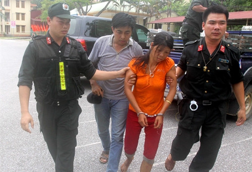Lực lượng công an áp giải nghi can Nguyễn Thị Hán . Ảnh: Thế Duyệt- TTXVN
