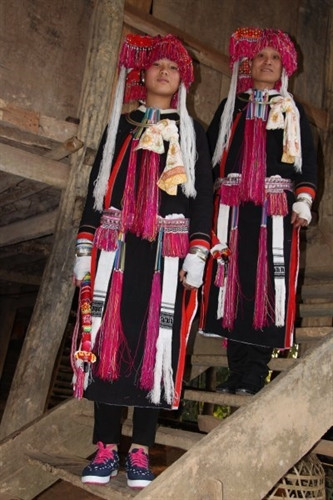 Bà đón và cô gái trẻ phụ bà đón gọi mặc váy áo sặc sỡ tua rua, mỗi người cầm 1 cái ô có tết hoa xanh, đỏ, vàng. Bà đón và cô gái trẻ phụ bà đón gọi mặc váy áo sặc sỡ tua rua, mỗi người cầm 1 cái ô có tết hoa xanh, đỏ, vàng.