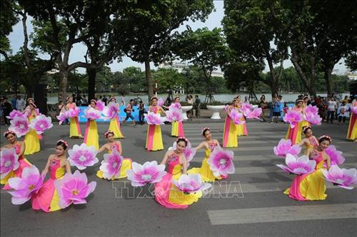 Tiết mục múa hoa đào tại Lễ hội đường phố chào mừng Lễ kỷ niệm. Ảnh: Lâm Khánh - TTXVN