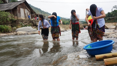Phụ nữ Thái gội đầu bằng nước vo gạo ủ từ 5 - 7 ngày được đựng trong ống tre Phụ nữ Thái gội đầu bằng nước vo gạo ủ từ 5 - 7 ngày được đựng trong ống tre