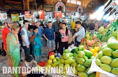 Du khách tham quan, tìm hiểu về các loại trái cây được bày bán tại chợ Bến Thành, thành phố Hồ Chí Minh. Ảnh tư liệu: An Hiếu