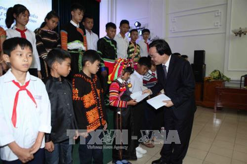 Bộ trưởng Bộ Giáo dục và Đào tạo Phùng Xuân Nhạ hỏi thăm, tặng quà cho các em học sinh có hoàn cảnh đặc biệt khó khăn được đỡ đầu trong Chương trình “Chiến sĩ quân hàm xanh nâng bước em tới trường”. Ảnh: Quý Trung – TTXVN