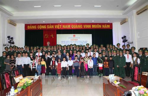 Các đại biểu với 60 cán bộ, chiến sĩ Bộ đội Biên phòng tiêu biểu và tặng quà cho các em học sinh có hoàn cảnh đặc biệt khó khăn được đỡ đầu. Ảnh: Quý Trung – TTXVN