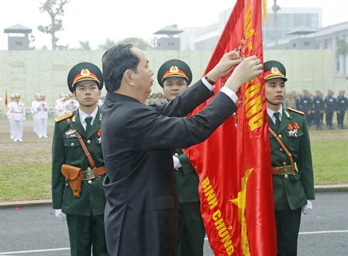 Chủ tịch nước Trần Đại Quang gắn Huân chương Quân công hạng Nhất lên lá cờ truyền thống của Bộ Tư lệnh Binh chủng Đặc công. Ảnh: Nhan Sáng-TTXVN