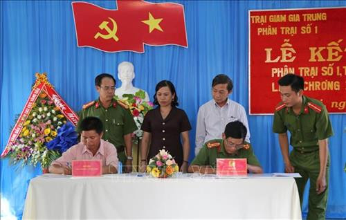 Đại diện Phân trại số 1, trại giam Gia Trung và làng ChRơng II ký kết văn bản kết nghĩa. Ảnh: Hoài Nam – TTXVN.