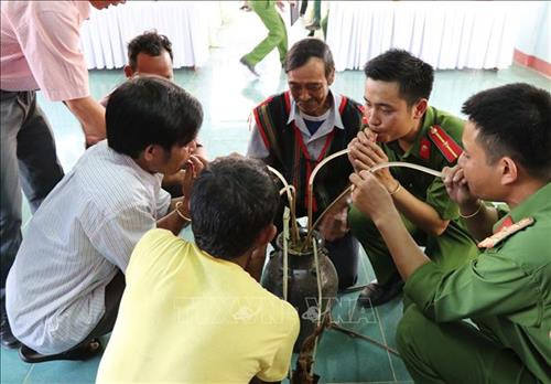 Cán bộ Phân trại số 1, trại giam Gia Trung và dân làng ChRơng II cùng uống rượu cần kết nghĩa. Ảnh: Hoài Nam – TTXVN.