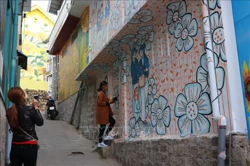 Du khách chụp ảnh với những tác phẩm nghệ thuật tại không gian Dốc Nhà Làng. Ảnh: Đặng Tuấn - TTXVN Du khách chụp ảnh với những tác phẩm nghệ thuật tại không gian Dốc Nhà Làng. Ảnh: Đặng Tuấn - TTXVN