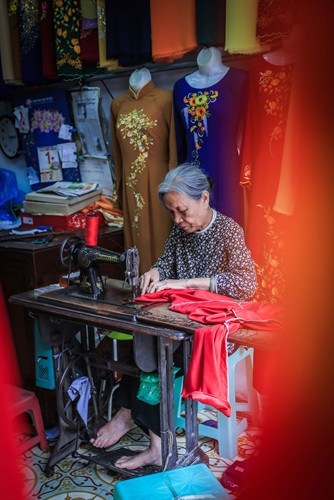 Bà Lê Thị Quyến, chủ hiệu áo dài Vinh Trạch ở phố Lương Văn Can, quận Hoàn Kiếm dù tuổi cao nhưng vẫn miệt mài bên bàn máy để trực tiếp làm ra những sản phẩm áo dài mang đúng thương hiệu của Trạch Xá. Bà Lê Thị Quyến, chủ hiệu áo dài Vinh Trạch ở phố Lương Văn Can, quận Hoàn Kiếm dù tuổi cao nhưng vẫn miệt mài bên bàn máy để trực tiếp làm ra những sản phẩm áo dài mang đúng thương hiệu của Trạch Xá.