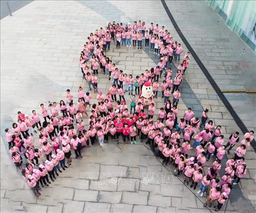 Xếp hình nơ hồng khổng lồ kêu gọi phụ nữ nâng cao nhận thức về bệnh ung thư vú. Ảnh: TTXVN phát