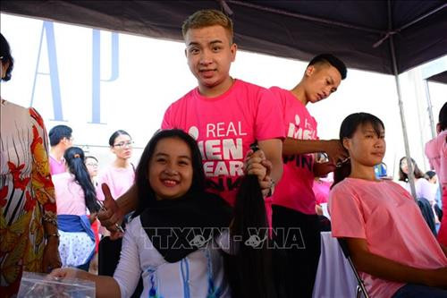 Bé Khánh Linh (9 tuổi) hiến tặng tóc tại Ngày hội Nón hồng 2018 để làm tóc giả tặng các bệnh nhân ung thư vú. Ảnh: Đinh Hằng – TTXVN