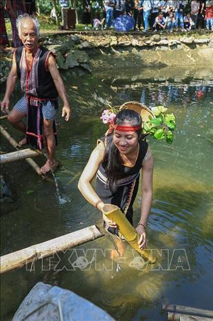 Những cô gái Xơ Đăng lấy nước vào ống nứa từ con nước đầu làng. Ảnh: Trọng Đạt - TTXVN