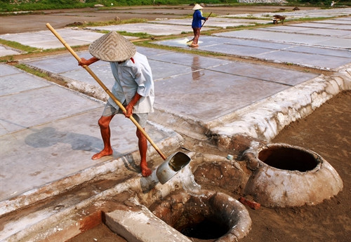 Nước biển sau khi lọc qua các lớp cát sẽ được múc mang ra sân phơi để làm muối.