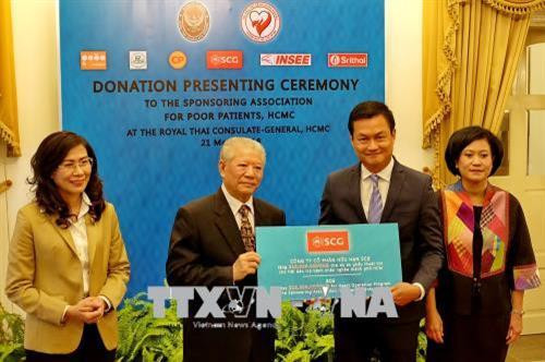 Ông Trần Thành Long (thứ 2 từ trái), Chủ tịch SAPP đón nhận bảng tượng trưng kinh phí hỗ trợ phẫu thuật tim cho bệnh nhân nghèo. Ảnh : Thế Anh-TTXVN