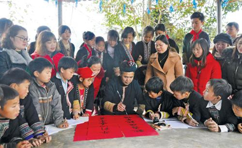 “Ông đồ” Tẩn Vần Siệu dạy học sinh viết câu đối Tết.