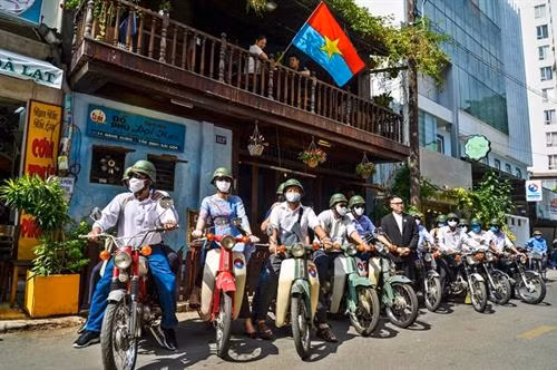 Đoàn du khách của tour "Theo dấu chân Biệt động Sài Gòn" lần đầu được trải nghiệm trên những chiếc xe cổ mà các chiến sỹ Biệt động năm xưa đã sử dụng hoạt động cách mạng. Ảnh: Hoàng Tuyết - TTXVN