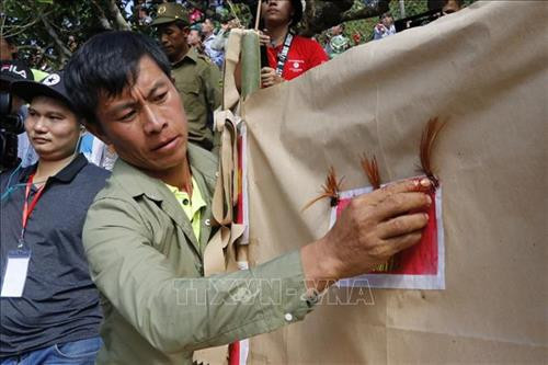 Tiết gà được đặt lên bàn thờ cùng với túm lông cổ được dán lên tờ giấy bản nơi chính giữa bàn thờ. Ảnh: Tuấn Anh-TTXVN