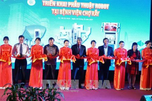 Các đại biểu cắt băng khai trương "Phẫu thuật nội soi robot". Ảnh: Phương Vy-TTXVN Các đại biểu cắt băng khai trương "Phẫu thuật nội soi robot". Ảnh: Phương Vy-TTXVN