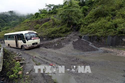 Bùn đất tại điểm sạt lở tràn ra mặt đường Quốc lộ 12 gây khó khăn cho các phương tiện tham gia giao thông. Ảnh: Phan Tuấn Anh - TTXVN