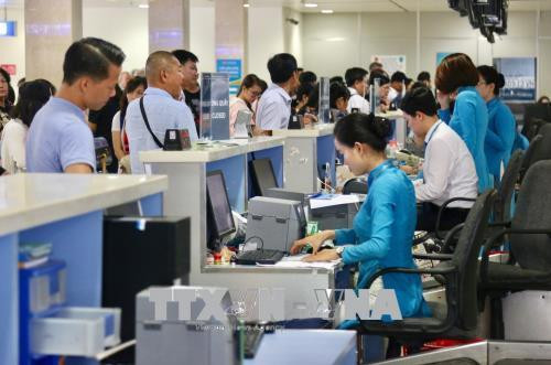 Hành khách làm thủ tục tại quầy của VietnamAirlines ở sân bay Tân Sơn Nhất. Ảnh: Trần Xuân Tình-TTXVN