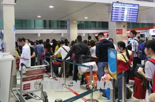 Hành khách làm thủ tục tại quầy của hãng hàng không Vietjet ở sân bay Tân Sơn Nhất. Ảnh: Trần Xuân Tình-TTXVN