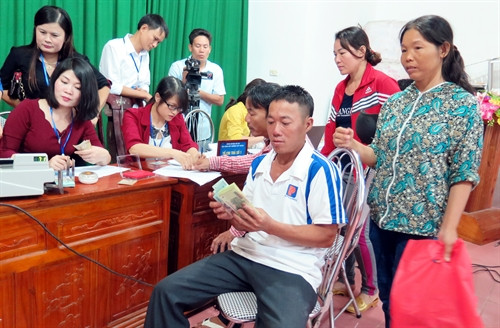 Người dân xóm Quang Trung, xã Thịnh Lộc, huyện Lộc Hà, tỉnh Hà Tĩnh nhận tiền bồi thường. Ảnh: Công Tường- TTXVN Người dân xóm Quang Trung, xã Thịnh Lộc, huyện Lộc Hà, tỉnh Hà Tĩnh nhận tiền bồi thường. Ảnh: Công Tường- TTXVN